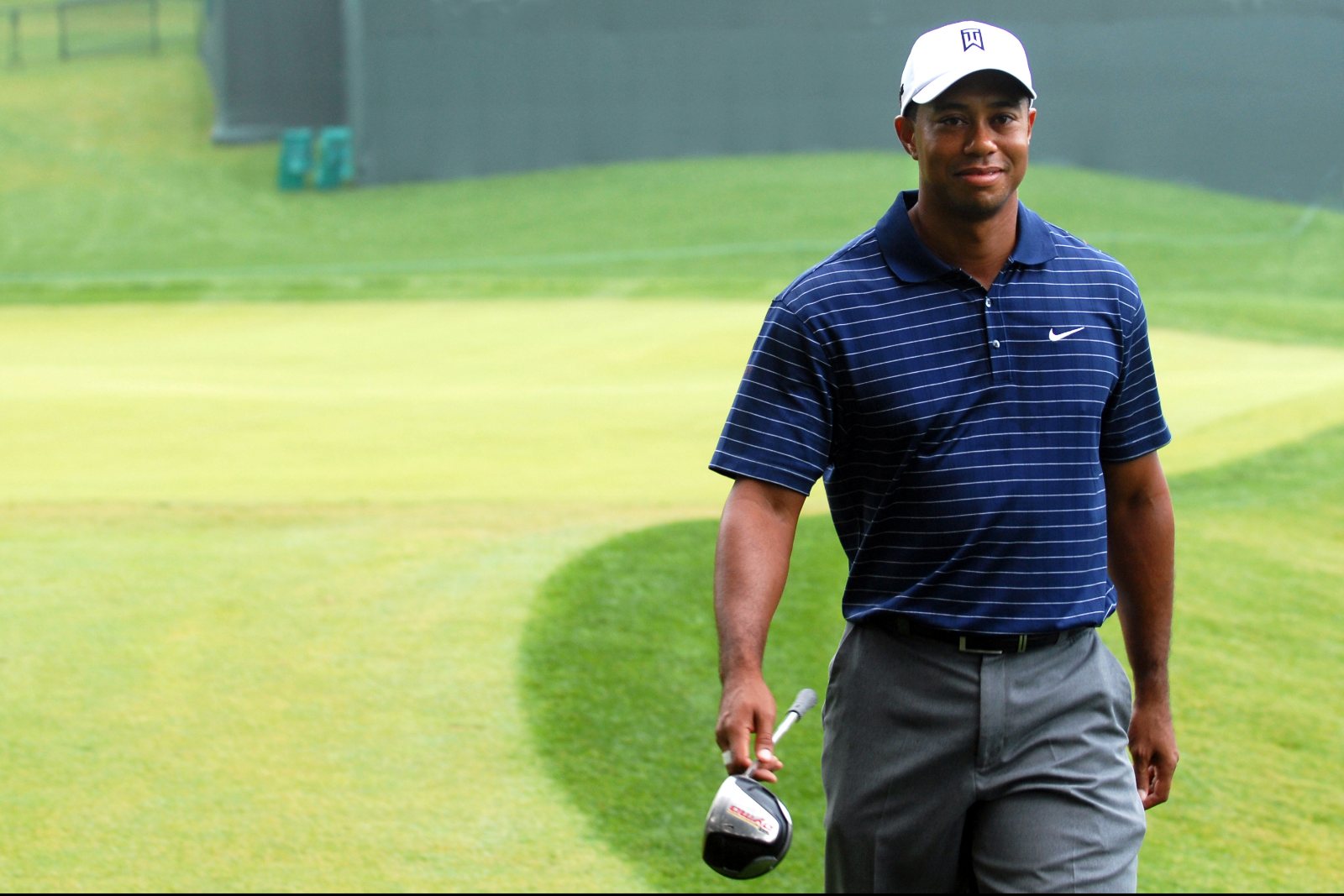 Tiger Woods walking a green with an iron in hand at the 2009 Earl D. Woods Memorial Pro-Am